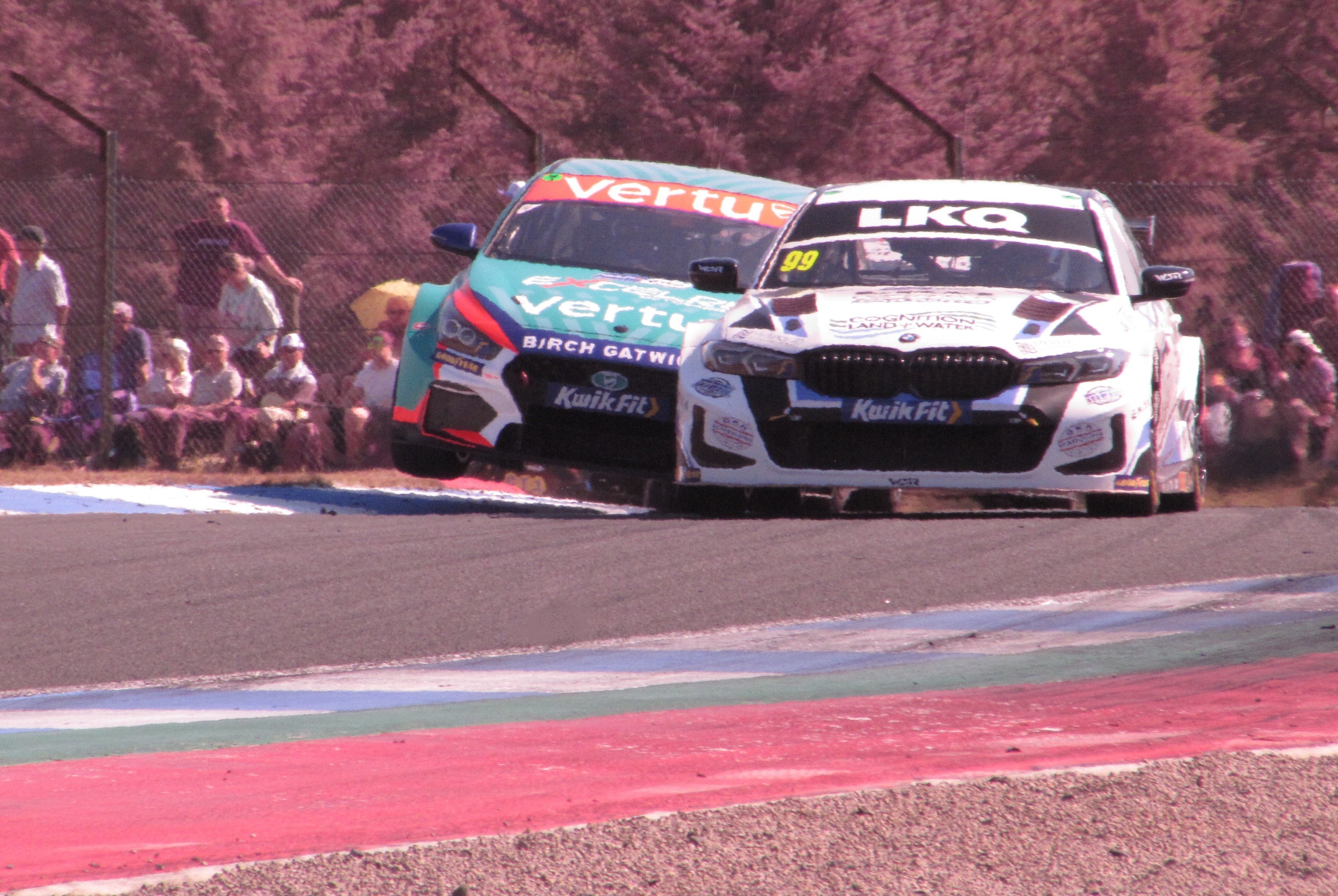 A photo taken at the 2025 BTCC round at Knockhill of a BMW 330i M Sport and Hyundai i30 N Performance Fastback heading through Clark's